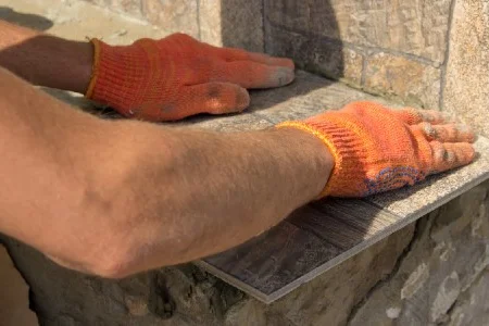 Person verlegt Fliesen